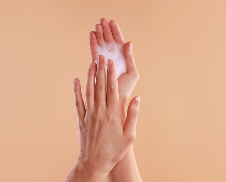 Weibliche Hände die Schaumlotion nutzen.